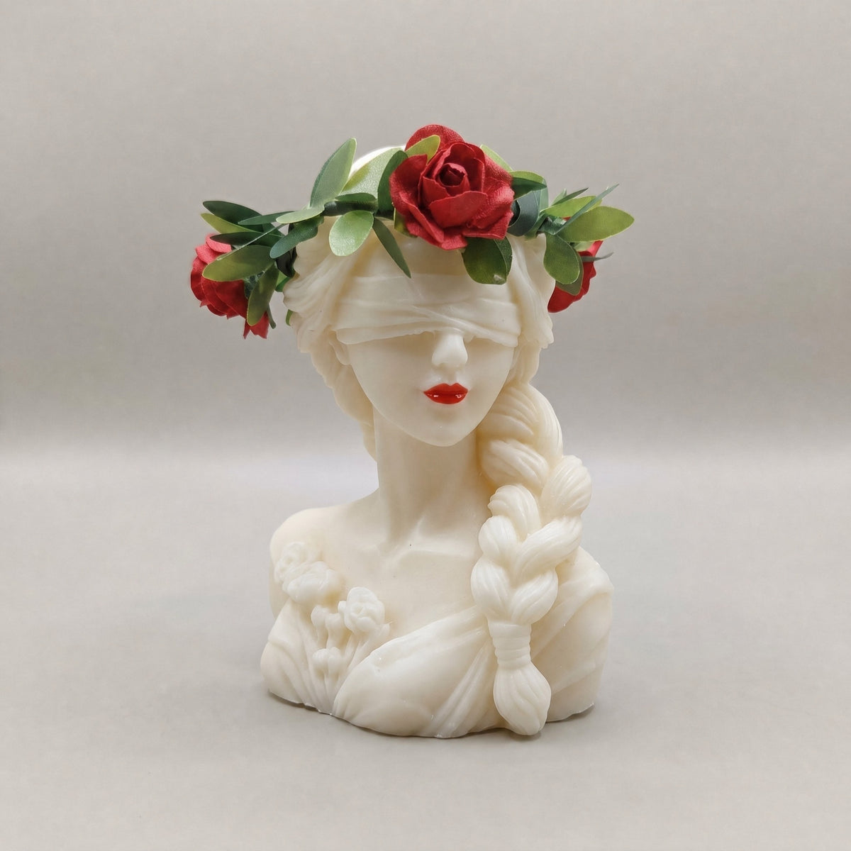 Candela Dea Bendata con treccia, corona di foglie verdi e rose rosse, labbra dipinte di rosso