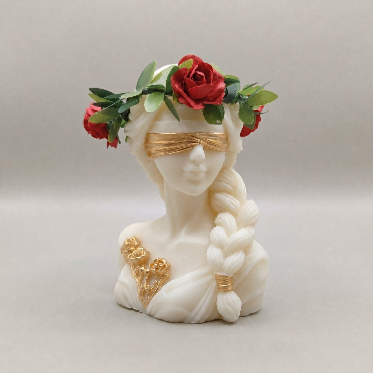 Candela Dea Bendata con treccia, corona di foglie verdi e rose rosse, benda e fiori rifiniti in oro